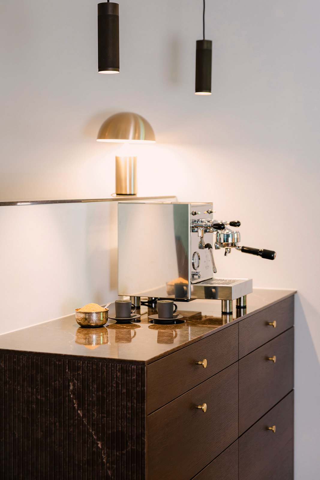 Kaffebraune Espresso-Bar Maßgefertigte Kaffeebar aus dunklem Holz mit brauner Marmorplatte und Messiggriffen.
